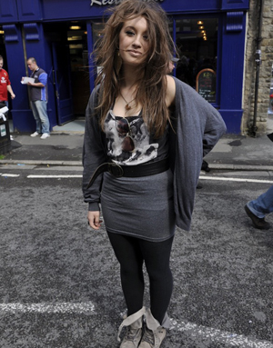 Street style contest wearing a shirt skirt, oversized t-shirt and knitted cardigan