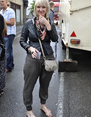 Street style contestant in a skinny fit leather jacket, harem pants and a colourful scarf
